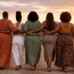 Five Black women of different body types walking arm in arm at sunset, symbolizing Ubuntu, community, connection, and collective growth.