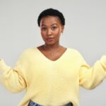 Woman reflecting on content creation while recording everyday life, representing authentic storytelling and consistent content creation.